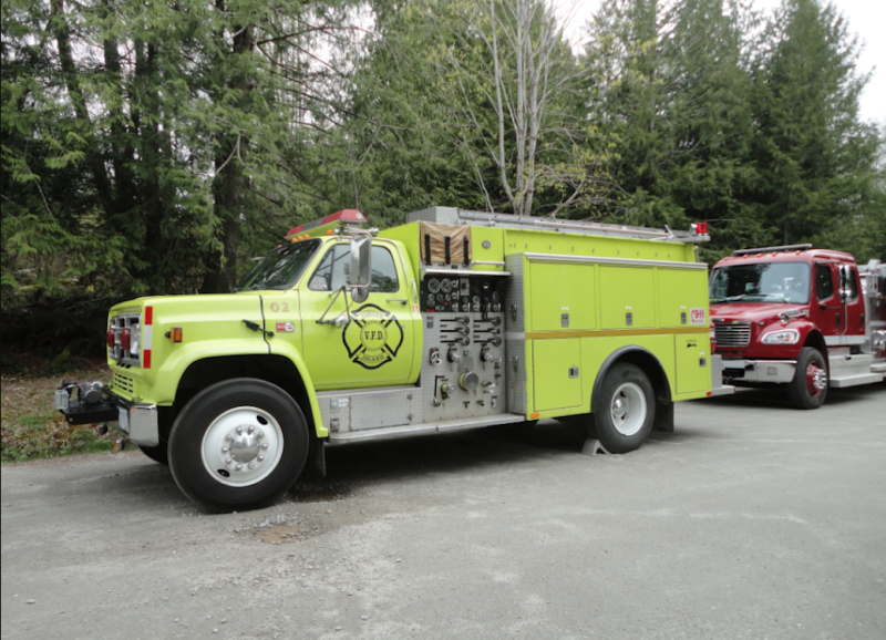 A green pumper truck at the side of the road