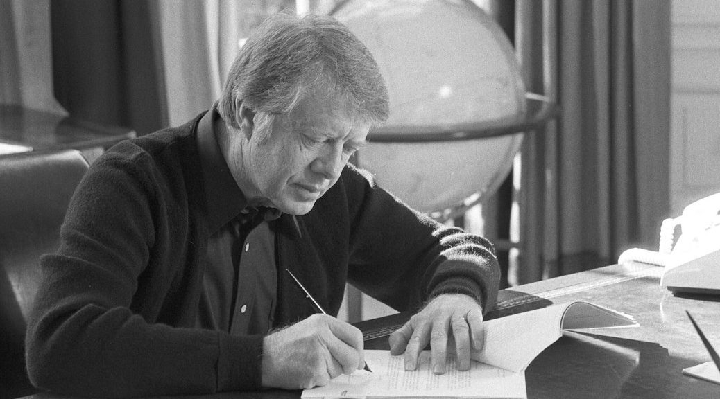 President Jimmy Carter signing a paper of some kind