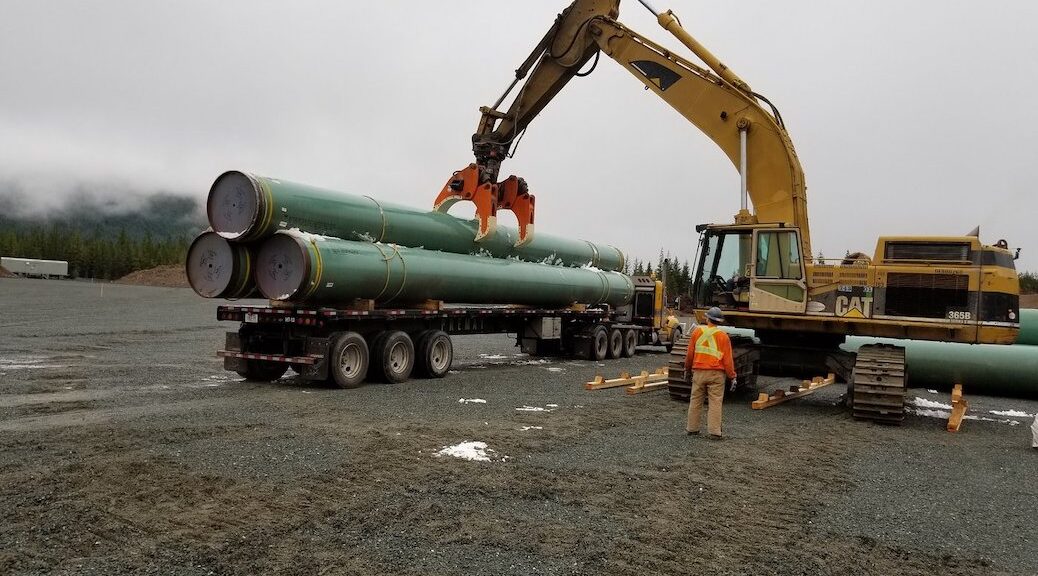 A machine takes pipeline segments from a truck