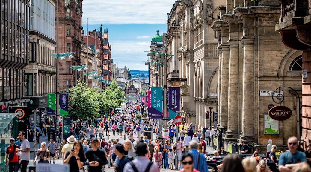 Pedestrians fill a crowded street in Glasgow