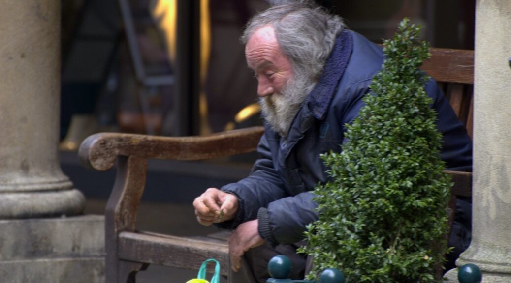 Homeless man sitting on a step