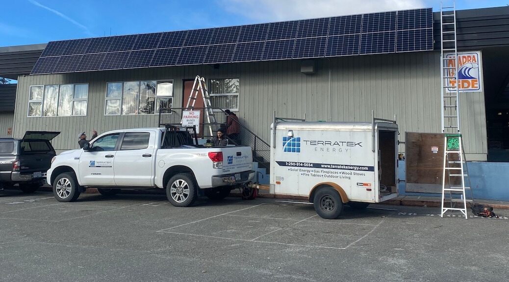 Terratek truck beneath the rooftop solar array on a school