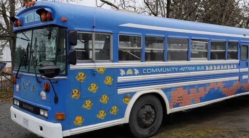 A blue bus with the words Community Action Bus painted on the side