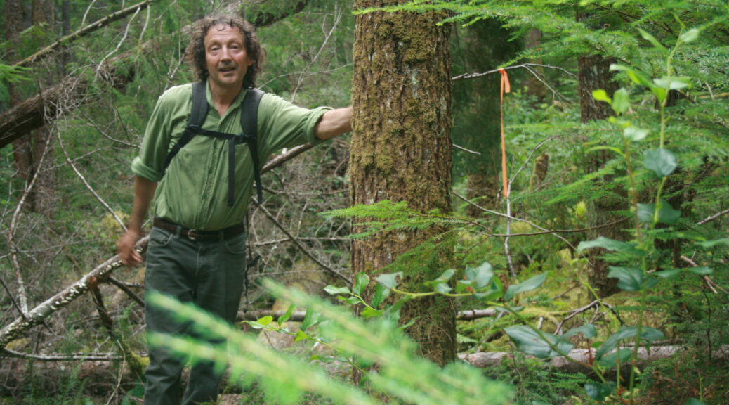 Man standing close to a red ribbon in the forest