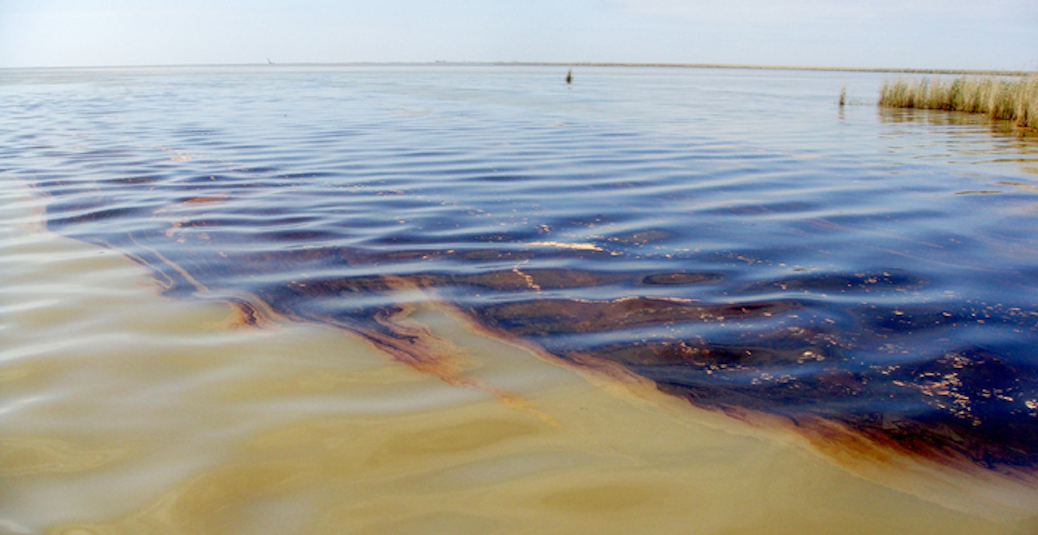 An oil spill spreading across a vast expanse of water