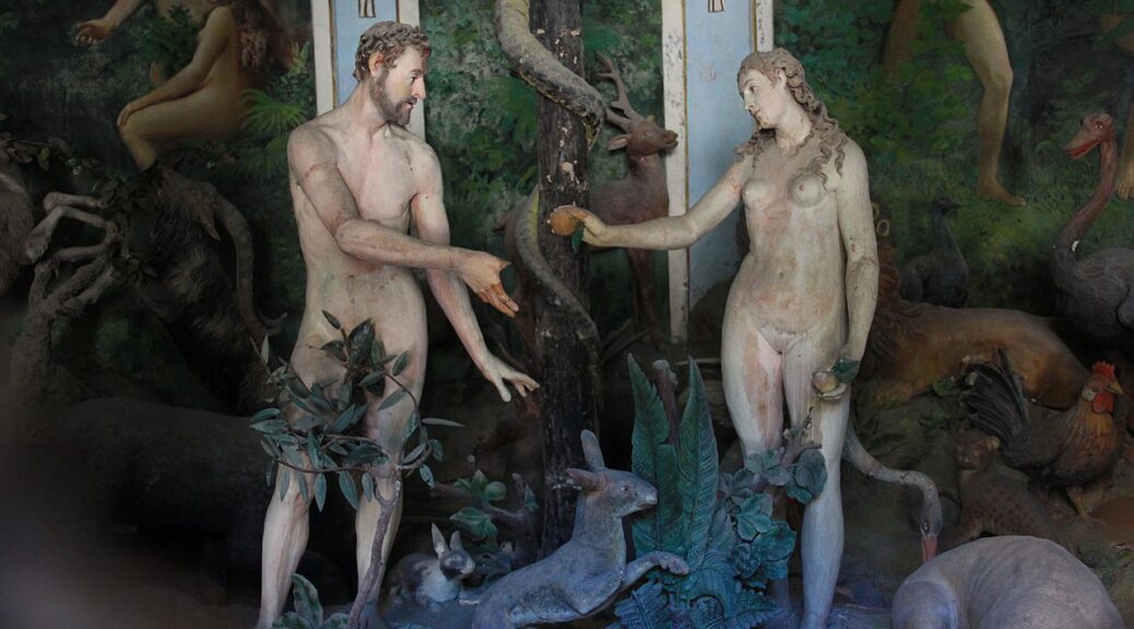 Statues of a naked woman passing an apple to a naked man
