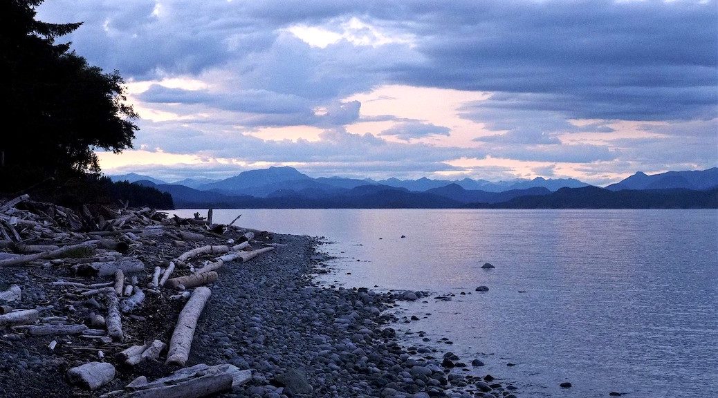 Looking from a rocky bech towards the mountains across the waters