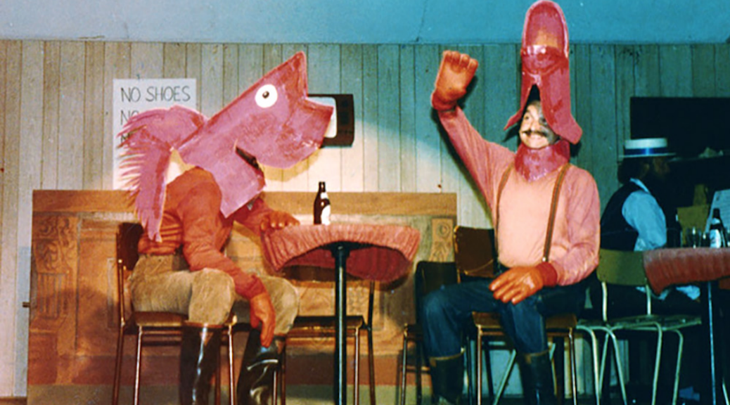 Two costumed performers, one dressed as a lumberjack and the other as a horse like animal, performing on stage