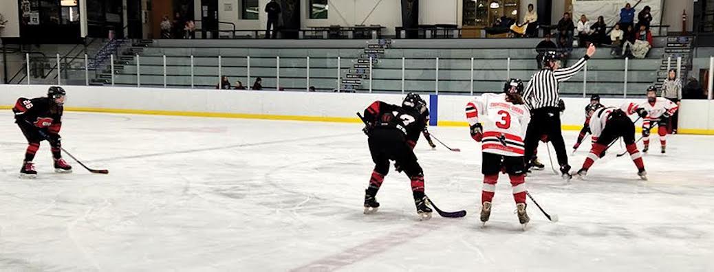 Two girls hockey teams face off on the ice