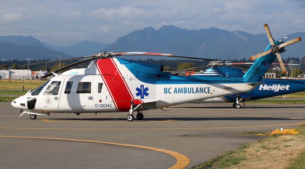 A helicopter with the words 'BC Ambulance' sits on the pavement