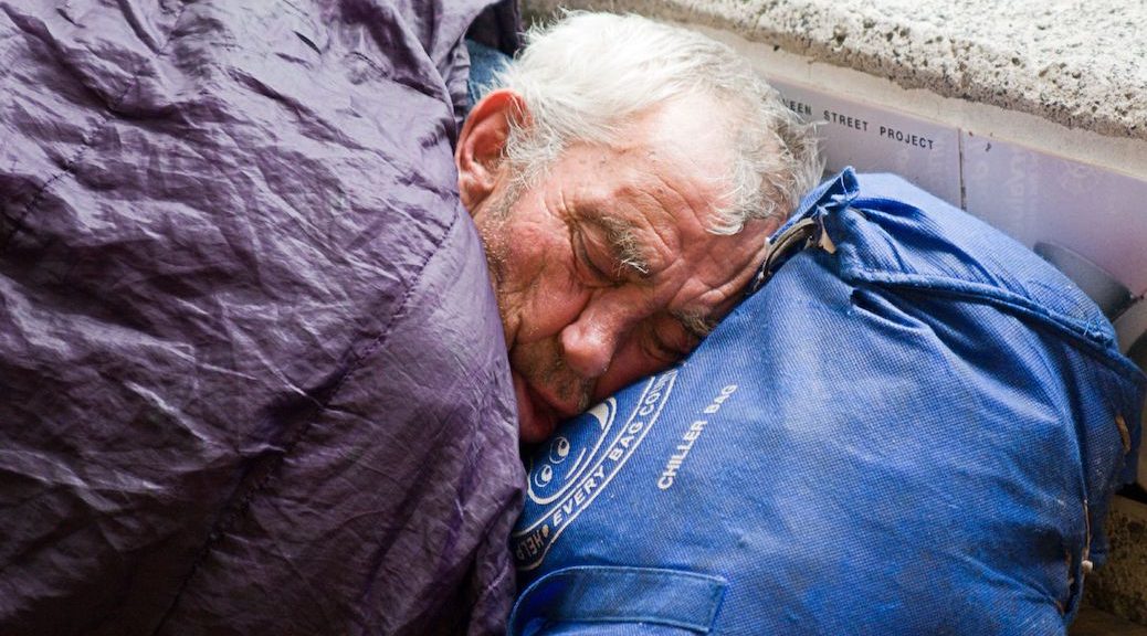 elderly man sleping in what appears to be a sleeping bag