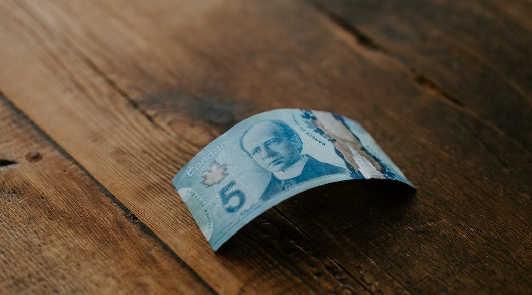 A $% Canadian bill on a hardwood floor