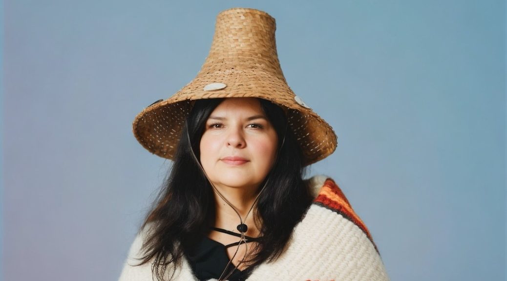 Indigenous woman wearing traditional cedar hat and robe