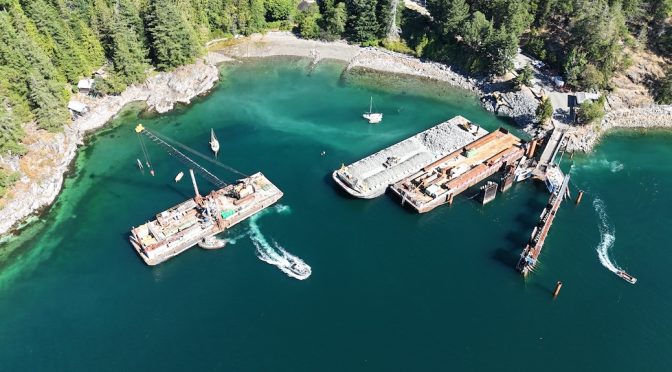 Aerial view of construction at a ferry terminal and a barge floating nearby