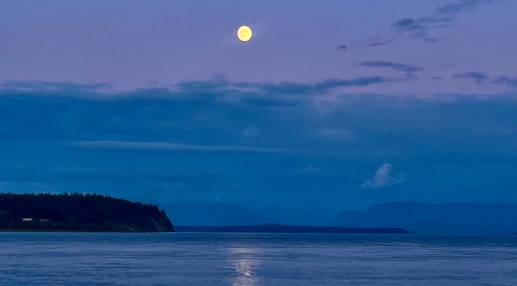 Moonrise through the clouds as the pink of sunset gives way to darkness on the islands