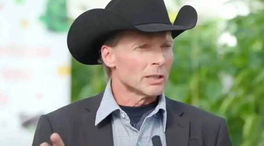 Angry looking man wearing a black cowboy hat