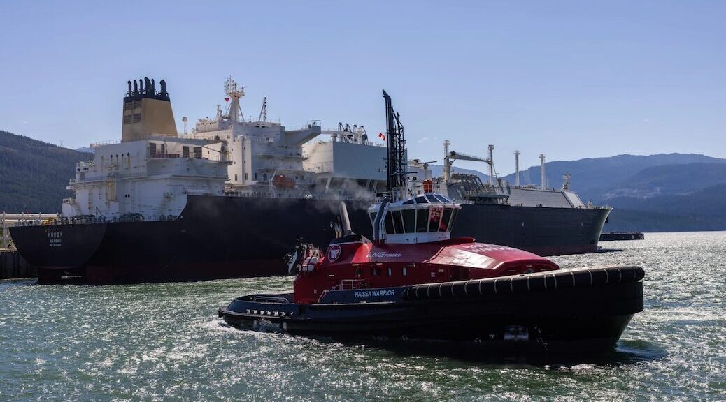 Tugboats approach an LNG freighter