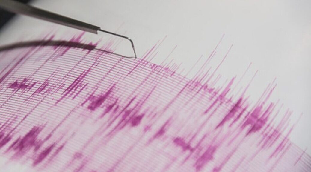 The needle of a seismogram tracing wave patterns on paper