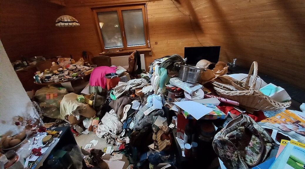 A room choked full of clothing and other stuff