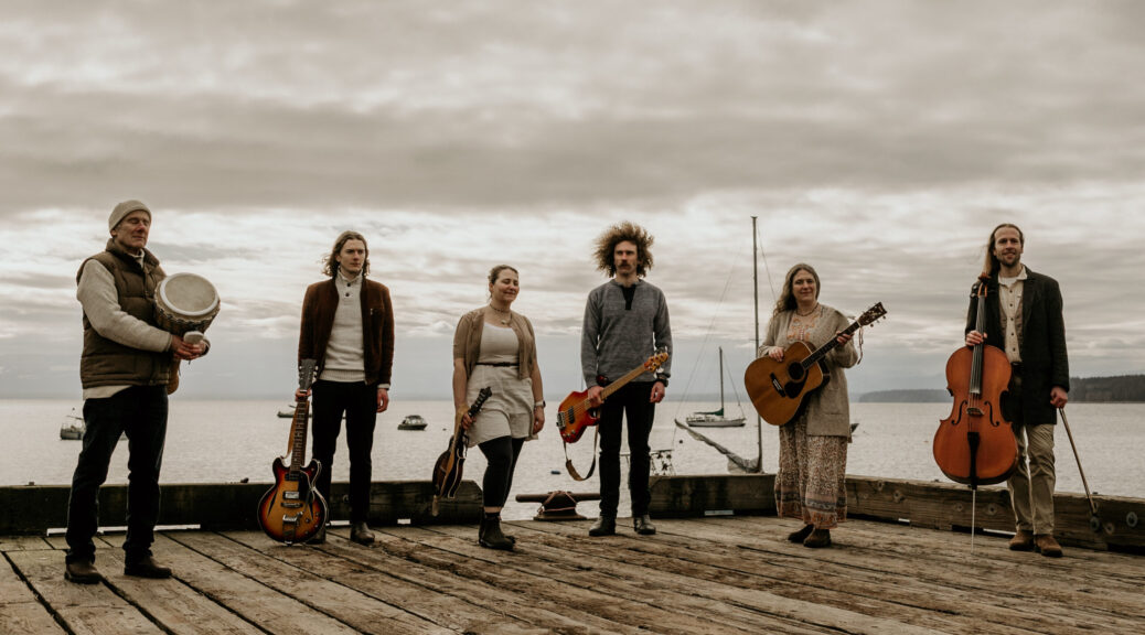 Six musicians standing on a wharf
